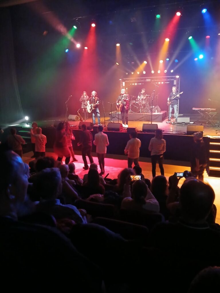 a group of people on a stage with a band on stage