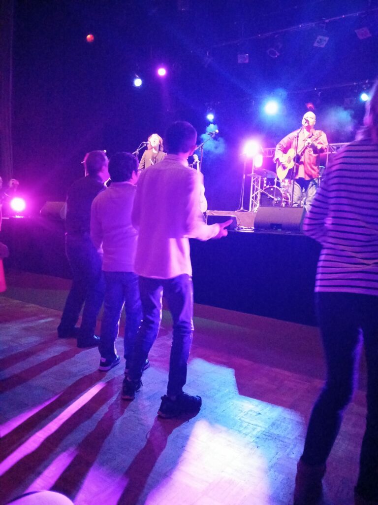 a group of people on a stage with a man playing guitar