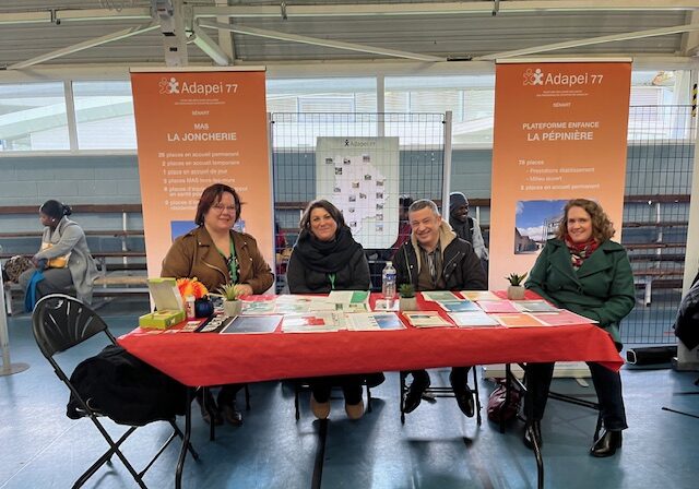 groupe de réprésentants de l'Adapei 77 aux forum de l'emploi sur fond de kakemono de la plateforme enfance et adulte